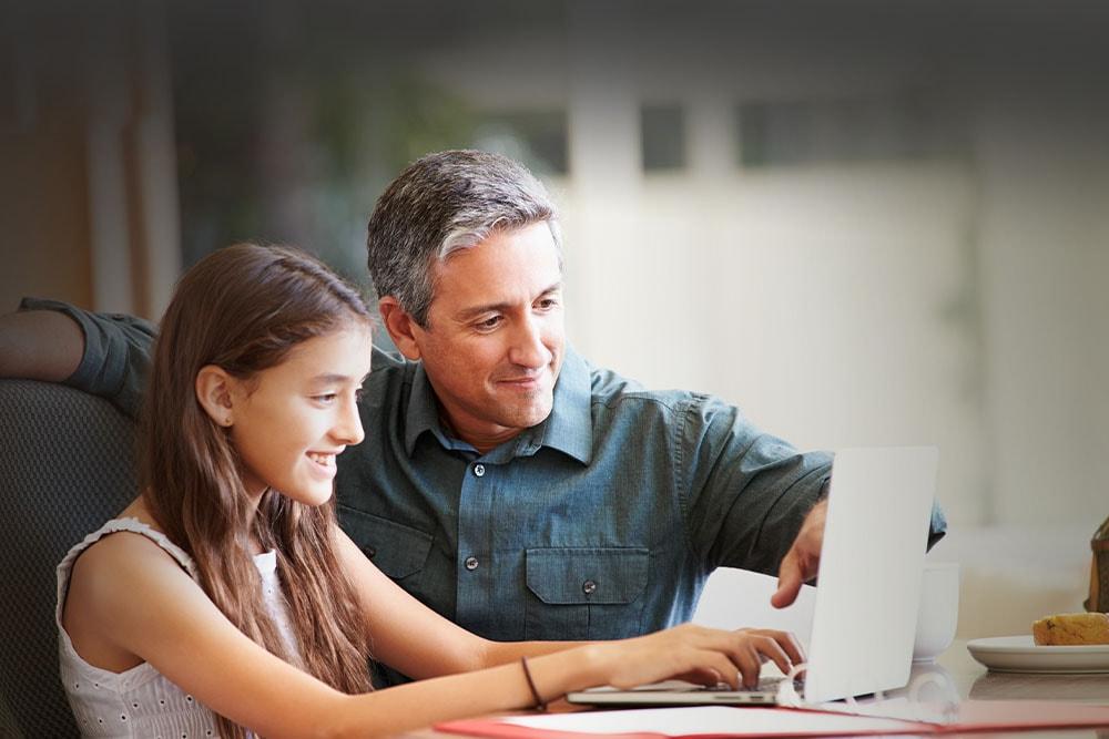 Female student in a white shirt smiling at the camera taking an online class with her learning partner at Texas Connections Academy. 